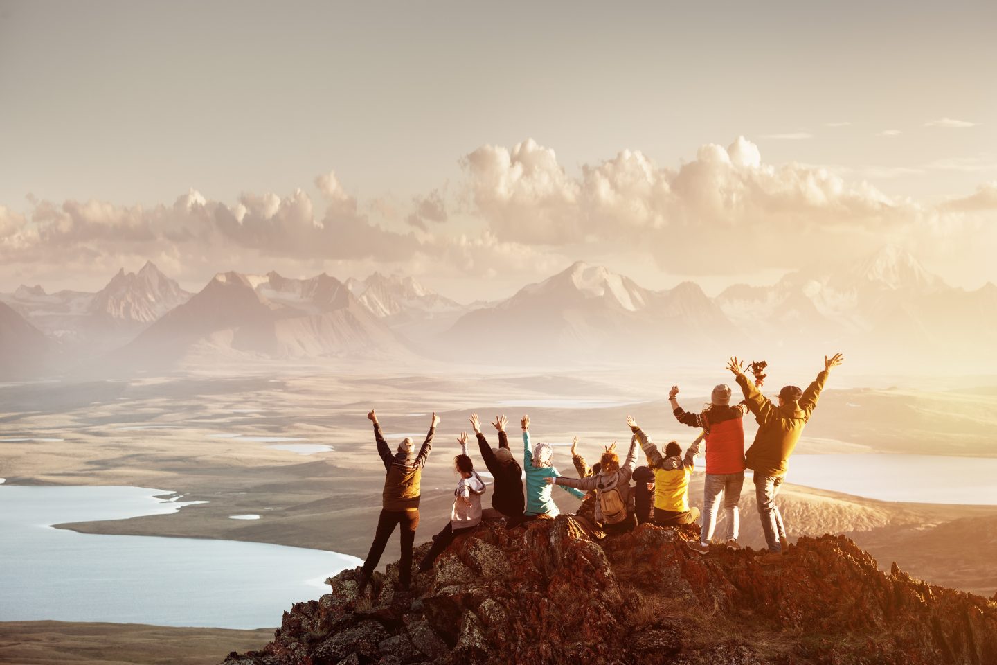A roped team climbing towards a summit at sunrise